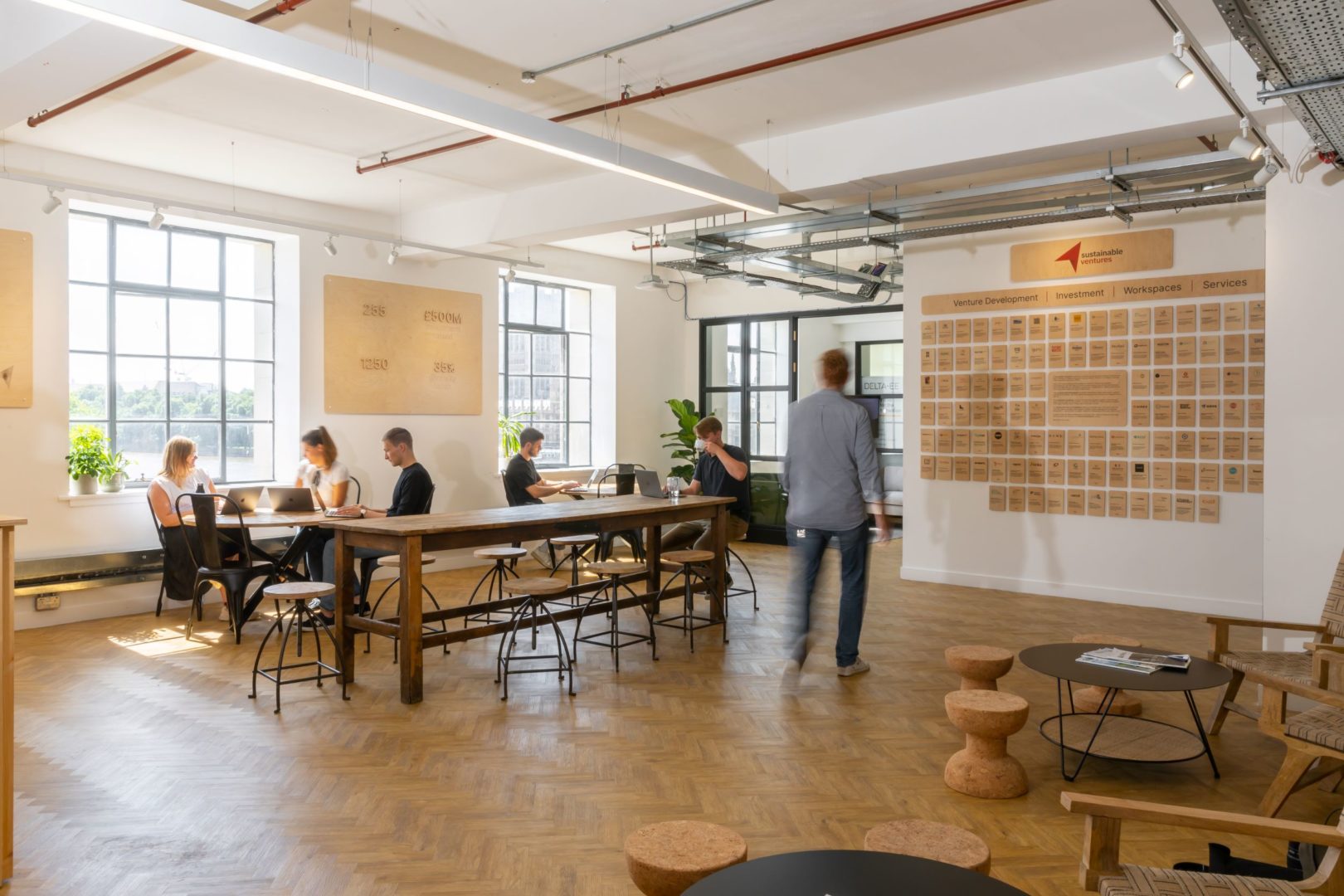 workspace with long desk in centre of image with people working