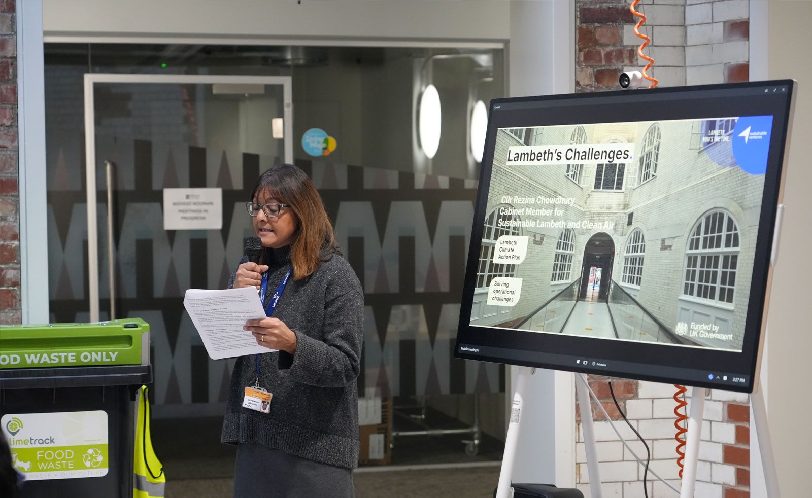 The Cabinet Member for Sustainable Lambeth and Clean Air stands speaking in front of the audience as part of the Pitch Day event.