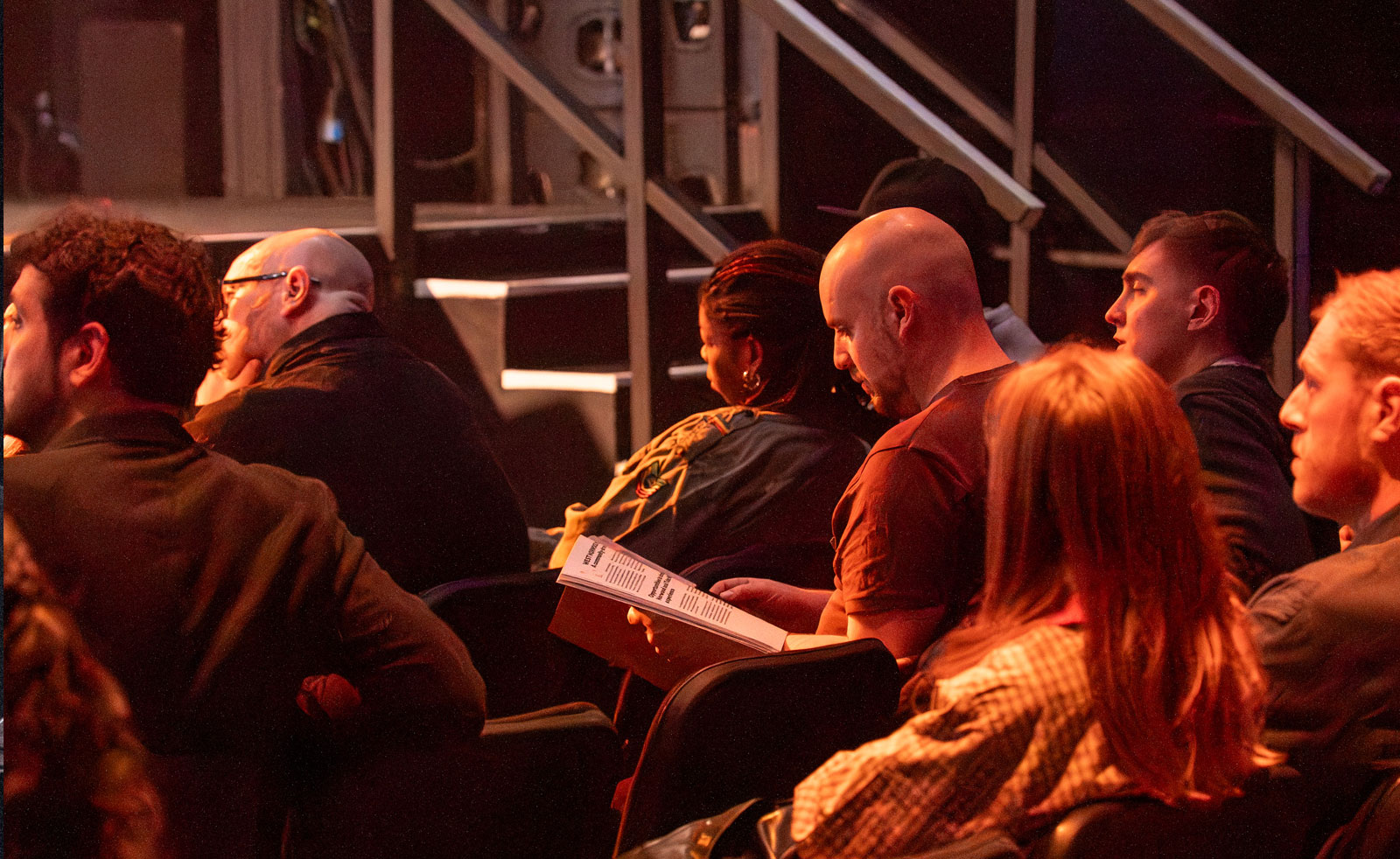 An image of people sitting down and looking through a document