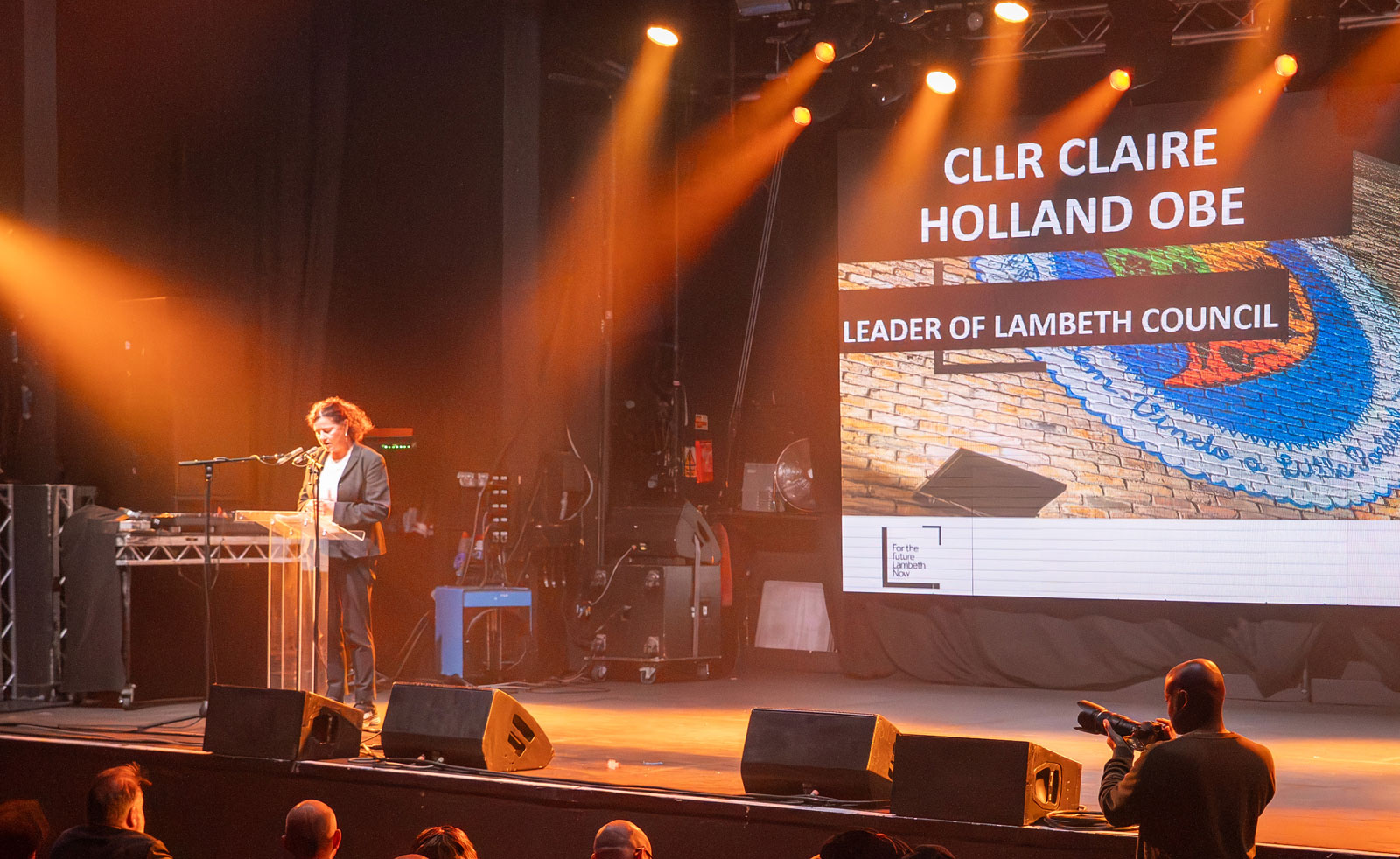 Lambeth's Leader, Councillor Claire Holland, speaking into a mic at a lectern onstage