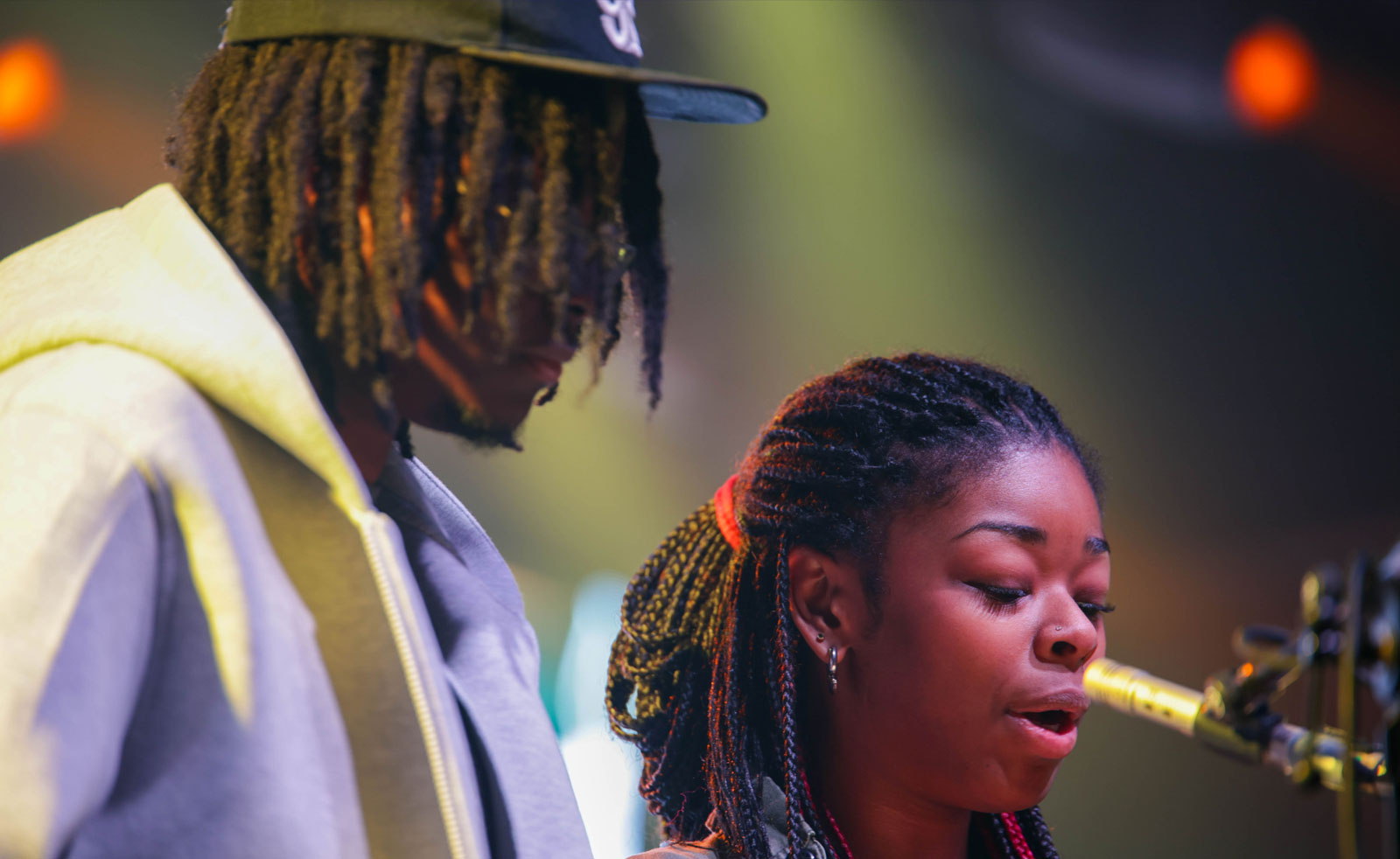 Two young people speaking into a mic on stage