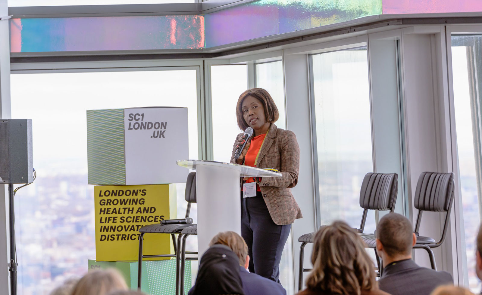 A black female speaks on stage at the SC1 event