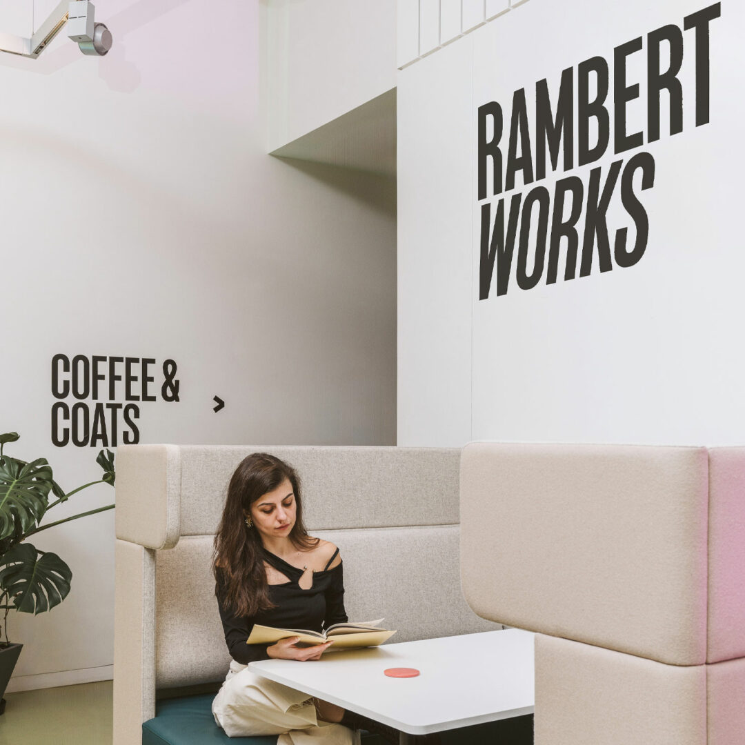 Young white woman reading in a booth at Rambert works creative workspace