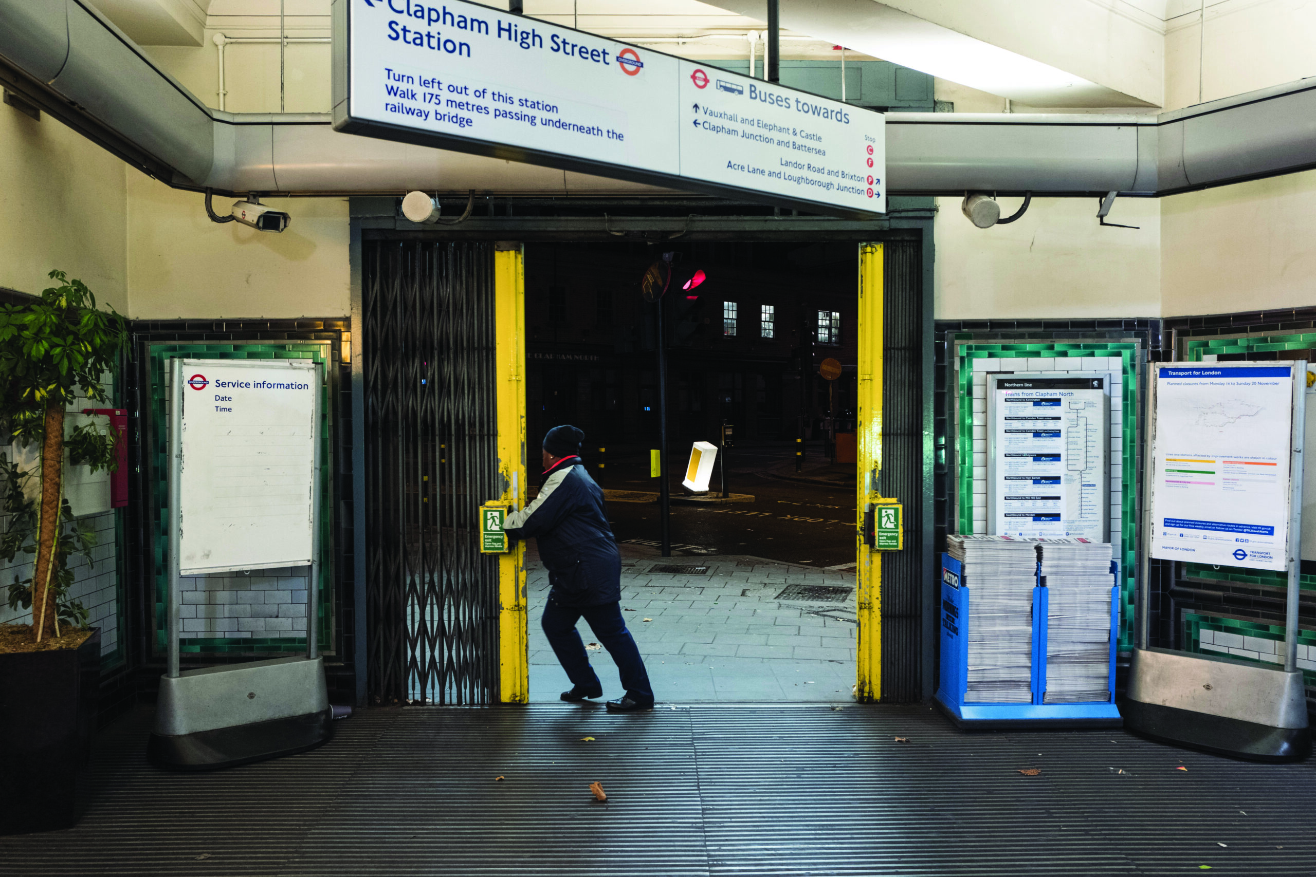 A Transport for London worker opening Clapham North station before dawn