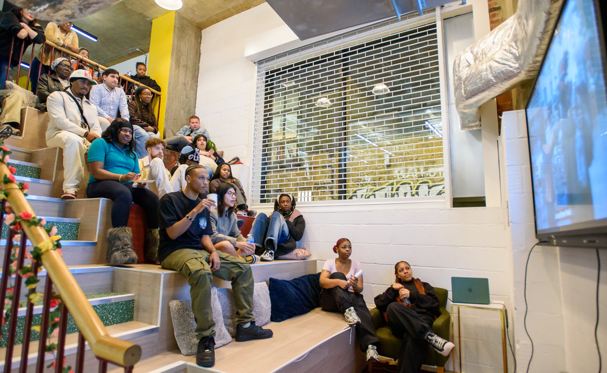 A group of about twenty young people sitting on tiered seating to watch a short film