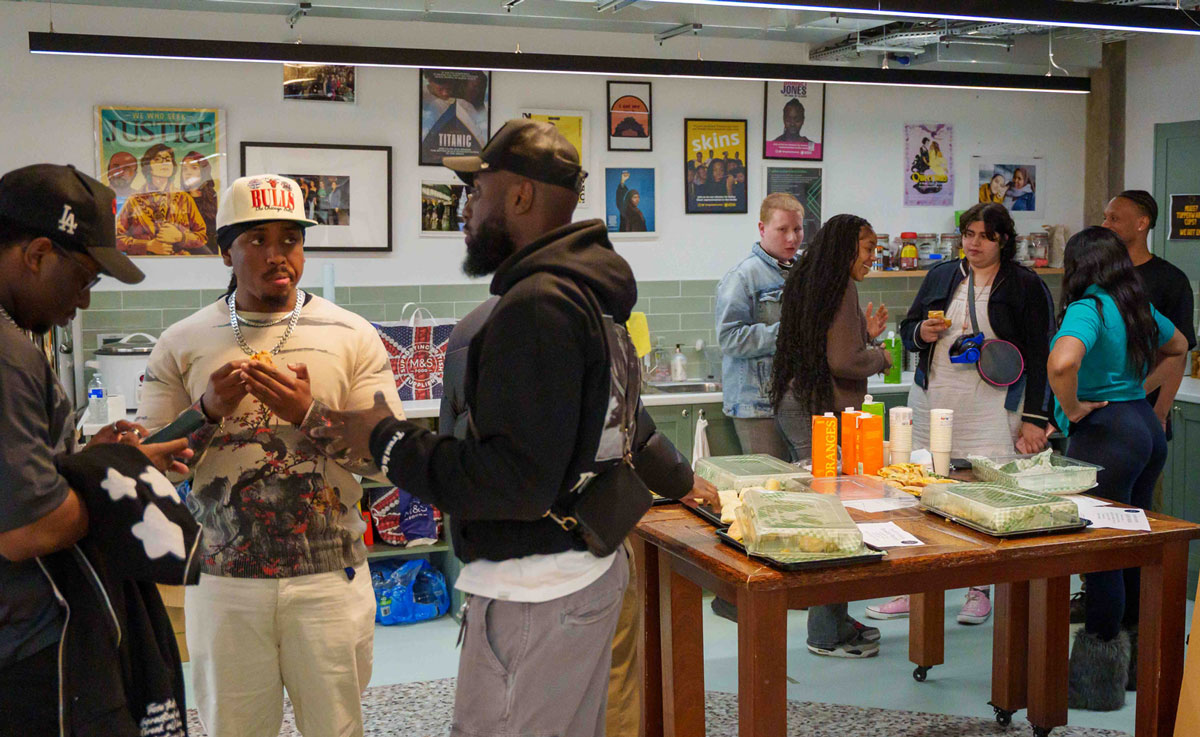 A group of young people chatting while standing with plates of food