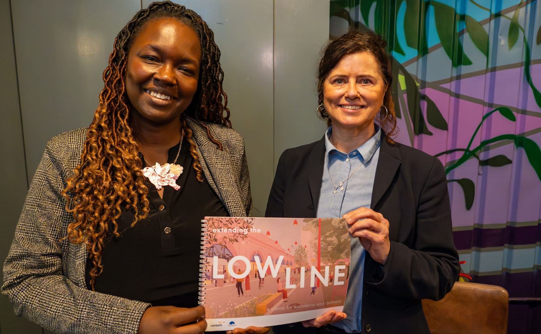 Lambeth's leader, Councillor Claire Holland standing with Wandsworth's Deputy Leader, Kemi Akinola, holding a printed copy of the Low Line Vision together