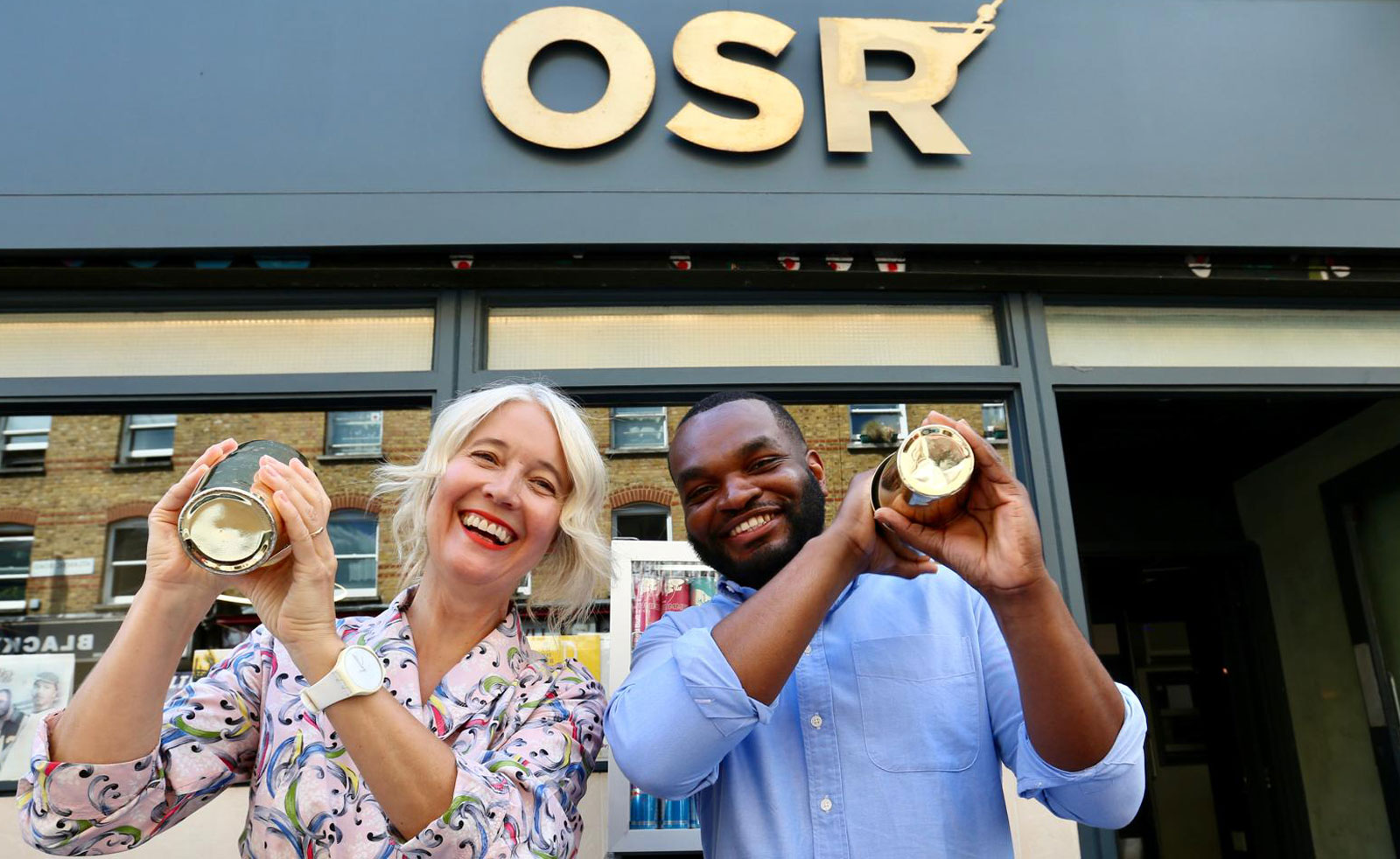 London's Deputy Mayor for Culture, Justin Simons, shakes a cocktail alongside a bartender outside a bar on Brixton's Atlantic Road