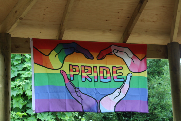 A Pride flag hanging under the roof of a gazebo at Vauxhall City Farm