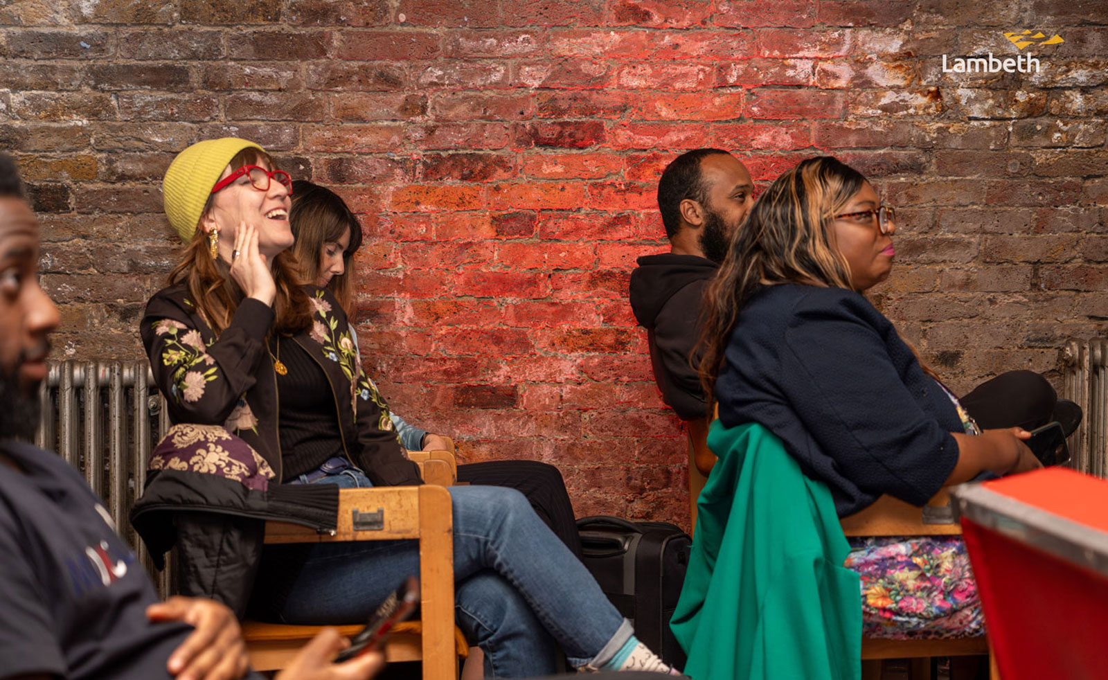 People at the end of programme celebration event watching the work created by young people.