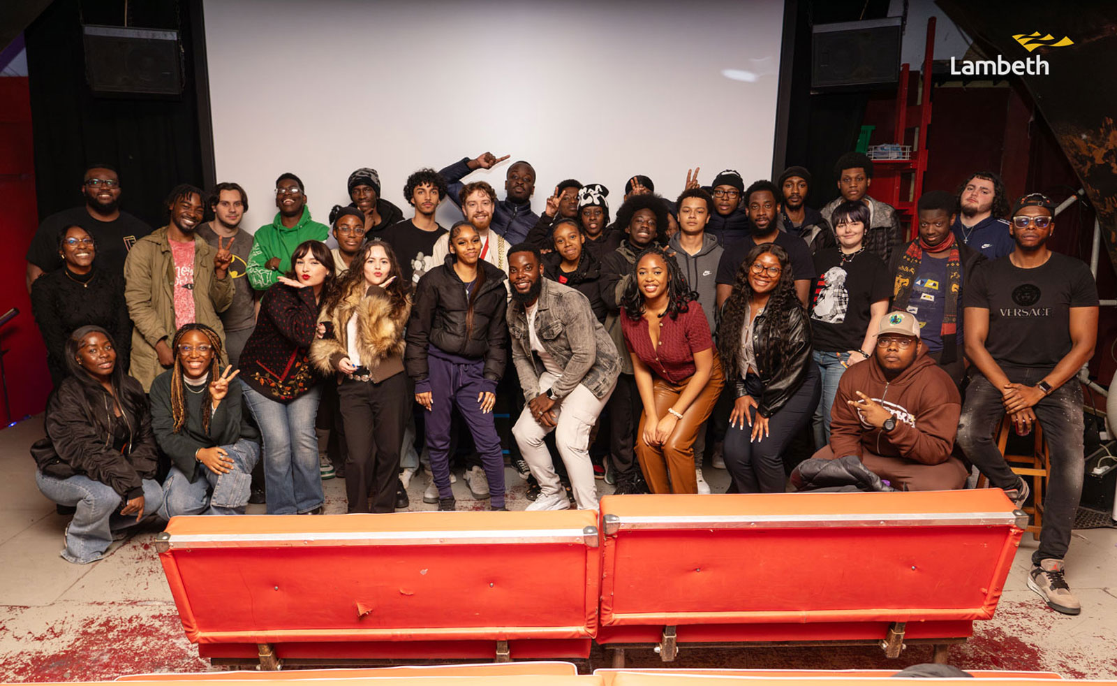 Group picture of young people and staff posing at celebration event