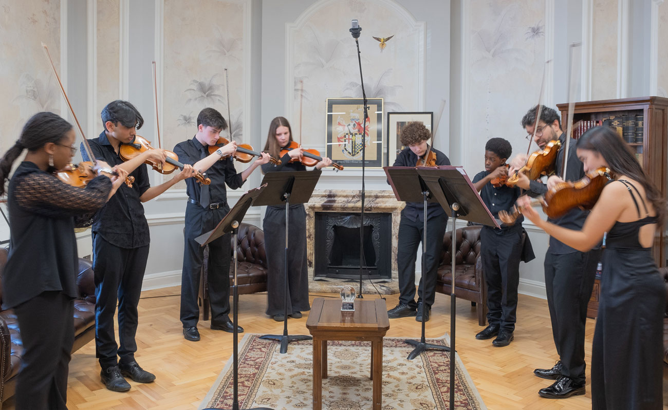 Eight young people playing the violin in Lambeth's Townhall