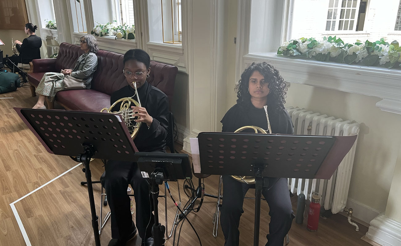 Two young people playing the french horn in Lambeth's Townhall