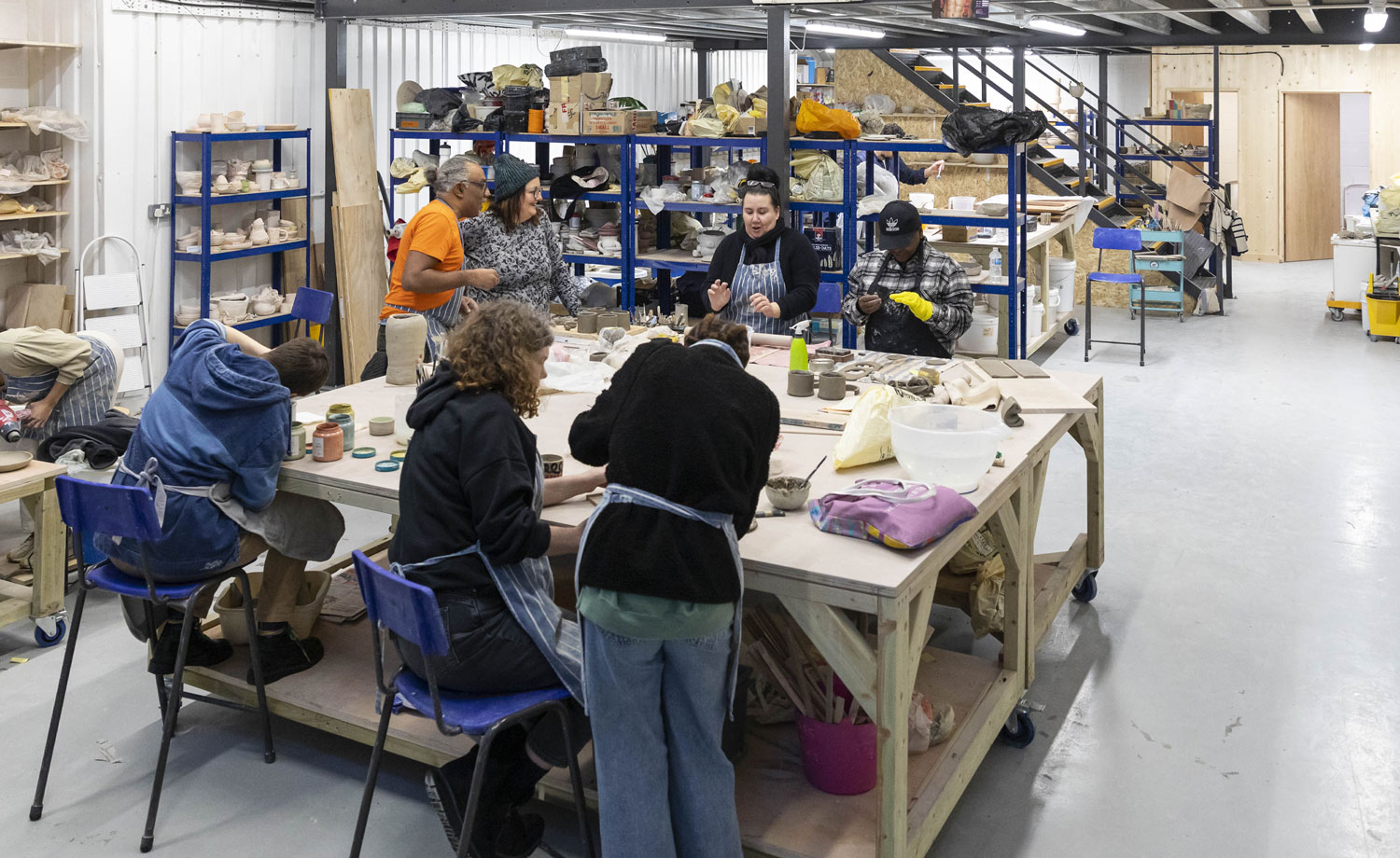 Group of people working with clay in pottery studio