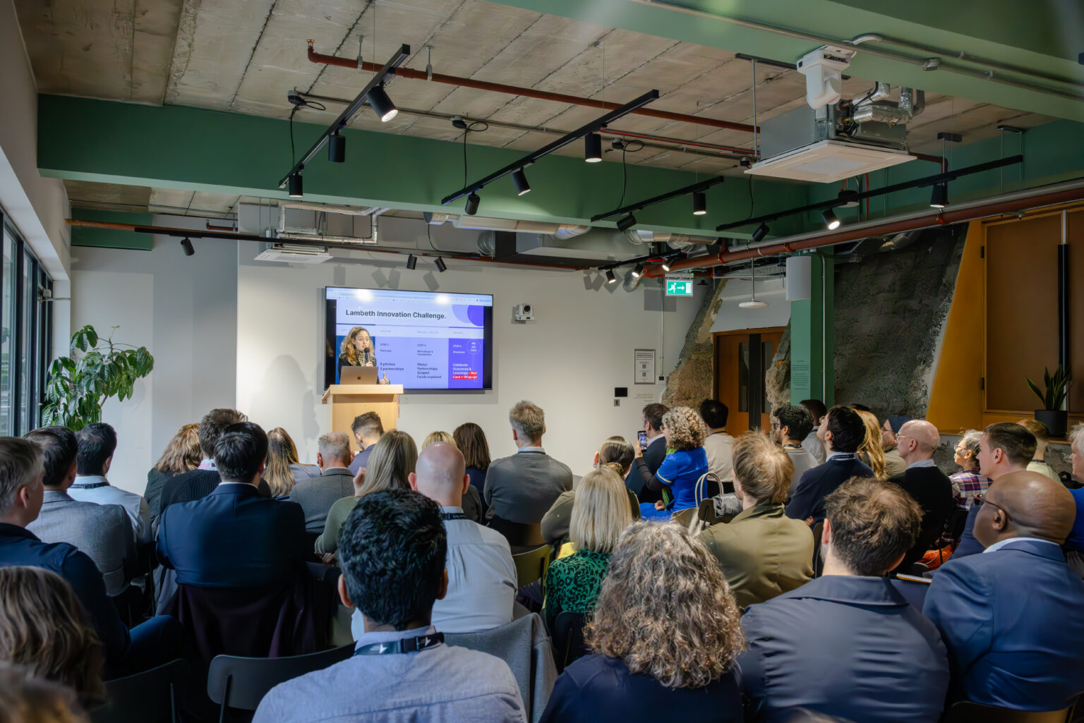 Audience sits in rows facing the speaker at the Innovation Challenge event