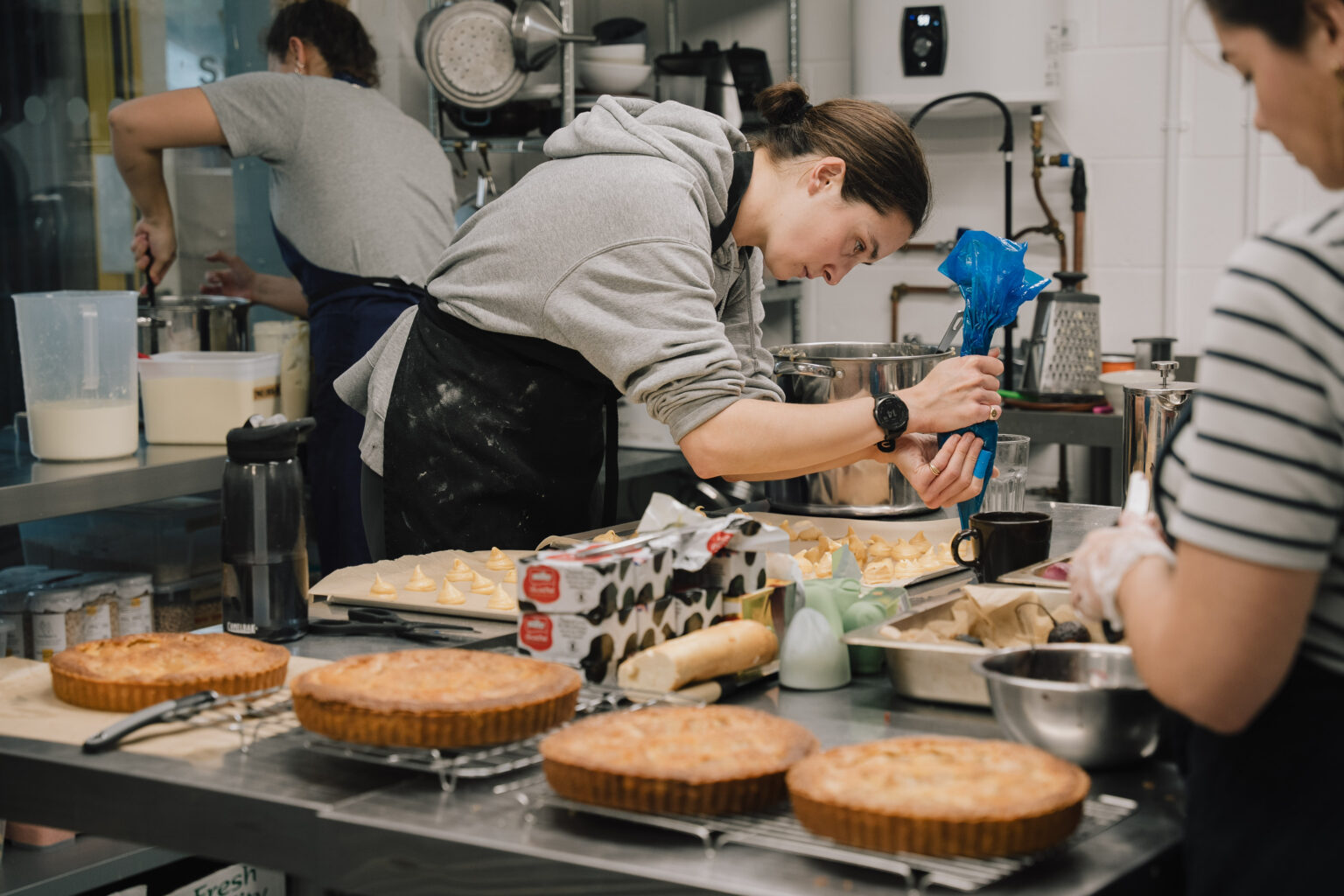 Staff at the vegan catering company business prepare cakes in a kitchen at LJ Works
