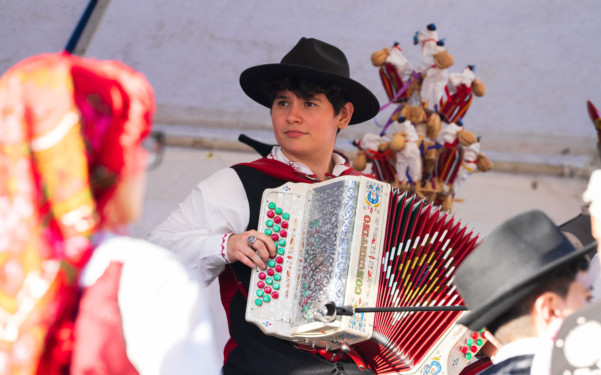 A young musician in traditional Portuguese dress plays the accordion during a cultural performance at the Day of Portugal celebration.