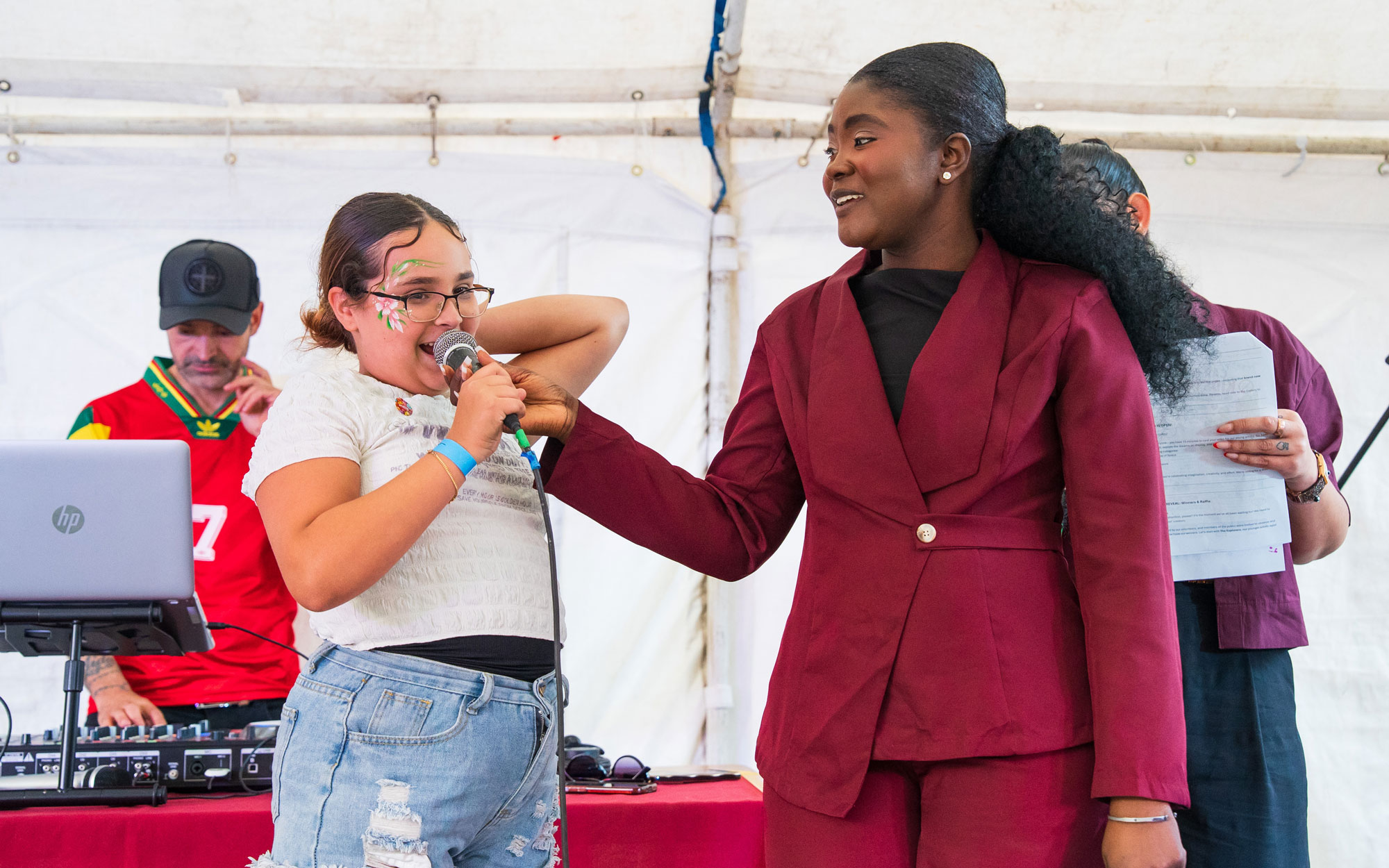 A young participant speaks on stage alongside an event host during the Day of Portugal celebration.