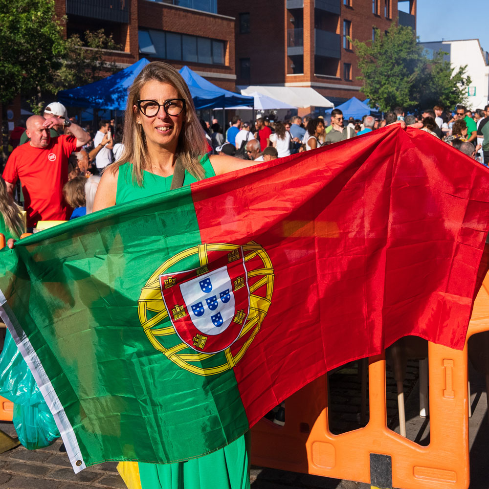 A visitor holds a Portuguese flag during Lambeth's Day of Portugal celebration in Little Portugal.