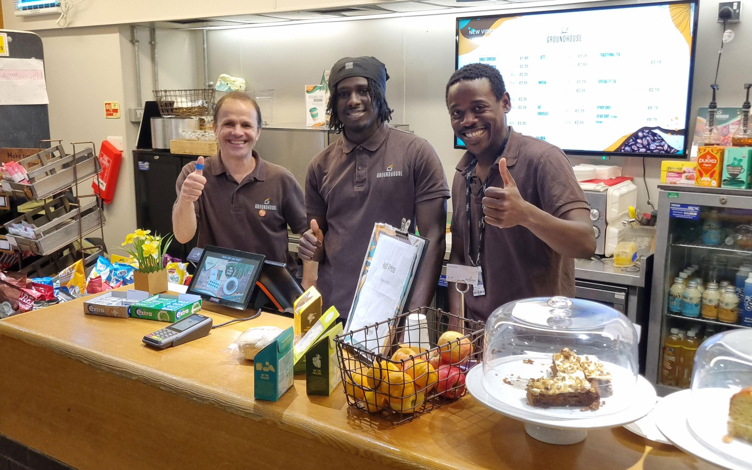 A new opportunity, Three members of The Foyer Café team stand behind the counter smiling and giving thumbs up.